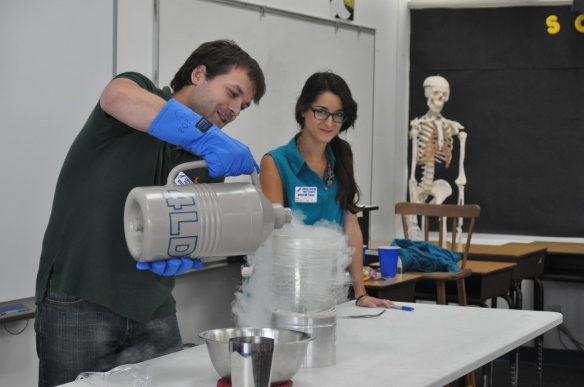 Carmen watches on as I pour the liquid nitrogen into the beaker, which boils like crazy until the beaker is chilled. The white gas is actually water vapor condensing from the air; nitrogen gas is transparent (think of your ability to see through air). Note, also, my previous assistant in the background - science can be taxing to the body.